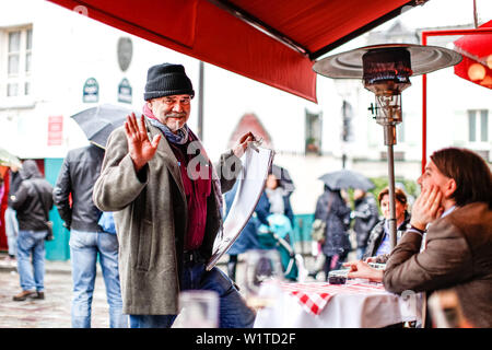 Street artist talking to a tourist at the La Mère Catherine restaurant, Place du Tertre, Montmartre, Paris, France, Europe Stock Photo