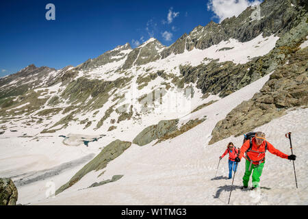 Man and woman hiking ascending through snow at Giro di Monviso, Giro di Monviso, Monte Viso, Monviso, Cottian Alps, France Stock Photo