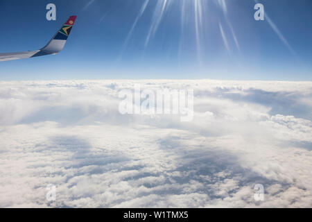Sun beams refracting in a airplane window above the clouds of South Africa. Stock Photo