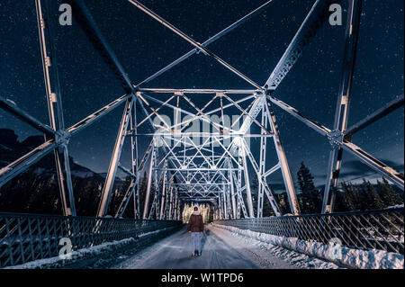 Man standing on a Bridge over Bow River at night, castle junction, Banff Town, Bow Valley, Banff National Park, Alberta, canada, north america Stock Photo