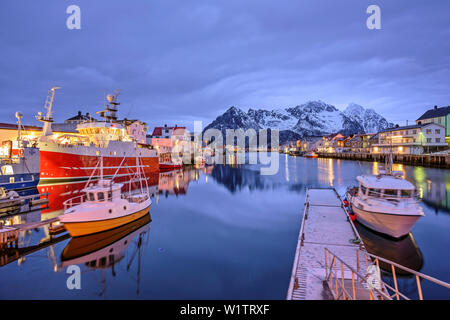 Harbour, ships and fisherman´s cabins in Henningsvaer at dusk, Lofoten, Nordland, Norway Stock Photo
