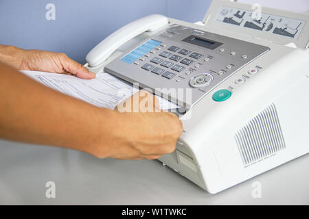 hand man are using a fax machine in the office Business concept Stock Photo