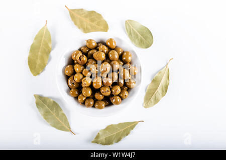 Green olives in bowl with leaves of Daphne on white background, Olives from Antakya, Turkey. Stock Photo