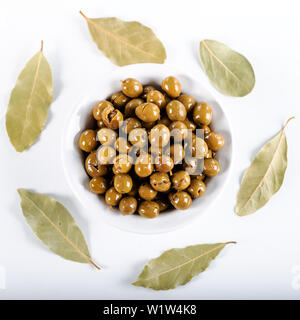 Green olives in bowl with leaves of Daphne on white background, Olives from Antakya, Turkey. Stock Photo