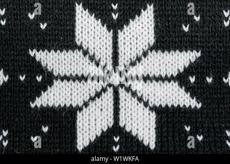 Detailed knitted black jacquard pattern with white flowers. Stock Photo