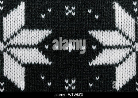 Detailed knitted black jacquard pattern with white flowers. Stock Photo