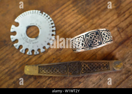 Hand crafted sterling silver bracelet with its casting mold and a wire gauge. Silversmith tools in a jewellery workshop in Taxco, Mexico. Jun 2019 Stock Photo