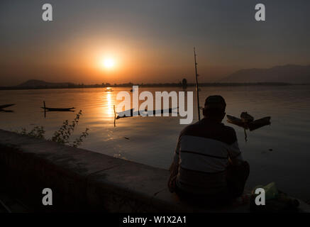 Srinagar. 3rd July, 2019. Photo taken on July 3, 2019 shows a fisherman catching fish during sunset at Dal Lake in Srinagar city, the summer capital of Indian-controlled Kashmir. Credit: Javed Dar/Xinhua/Alamy Live News Stock Photo