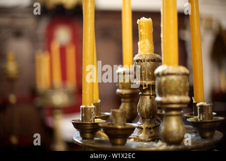 Large wax candles in a candlestick in a Christian church. Stock Photo