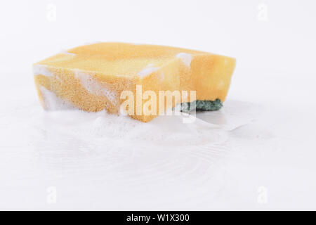 Old dish-washing sponge full of foam on a white background Stock Photo