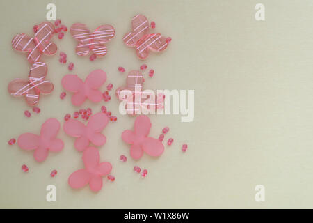 Oval beads and butterfly beads on a beige background. Use as a background, cards. Handicraft and hobby accessories Stock Photo