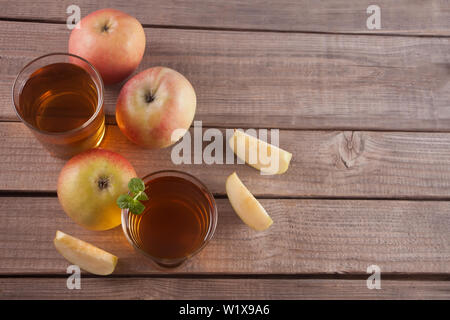 Two glasses of apple juice and apples on wooden table. Copy space. Top view. Stock Photo