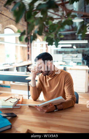 Man feeling tired. Bearded dark-haired man feeling tired and sleepy after working for tool long Stock Photo