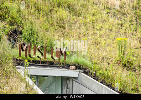 Werkendam, The Netherlands, July 3, 2019: corten steel letters surrounded by grass and wildflowers indicate the entrance to the Biesbosch museum Stock Photo