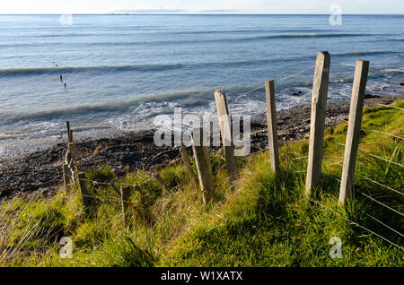 Fence beside beach and sea, Glenburn, Wairapapa, North Island, New Zealand Stock Photo