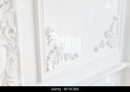 Luxury interior. Stucco elements on light wall. White patterned. Mouldings element from gypsum. Roccoco style. Stock Photo