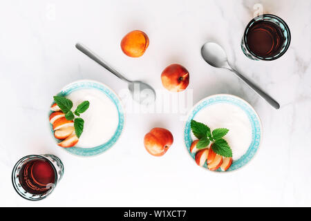 Top view of healthy breakfast of natural greek yoghurt, nectarines and juice on marble table. Flat lay. Stock Photo