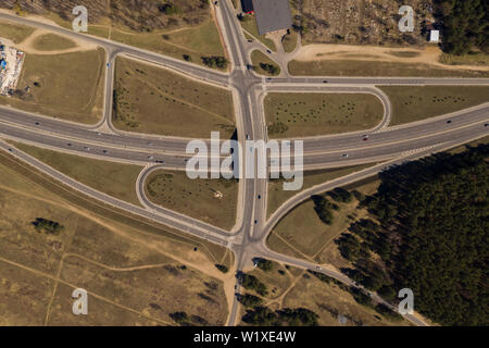 Highway interchange seen from above. Drone view of highway road junction in the city suburbs. Stock Photo