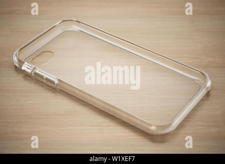Transparent silicone smartphone cover standing on wooden surface. 3D illustration. Stock Photo