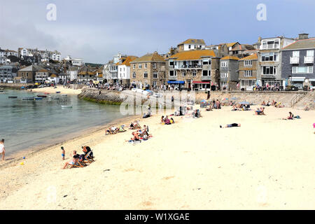 St. Ives, Cornwall, UK. June 25, 2019. Holidaymakers walk the Warf and Warf road also relaxing on the sand beaches at St. Ives in Cornwall, UK. Stock Photo