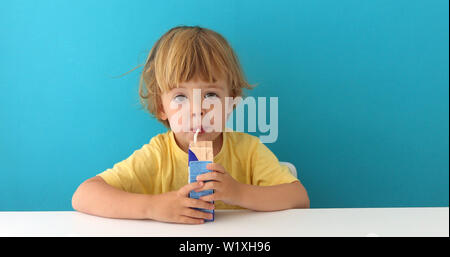 Adorable child drinking from box through straw Stock Photo