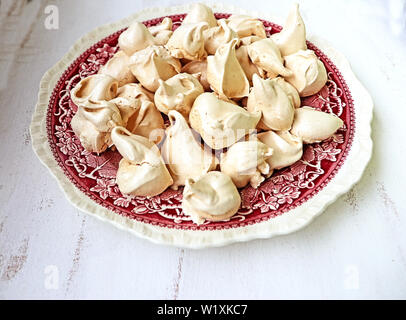 Homemade meringues cinnamon  and vanilla  flavored on a vintage ceramics plate, delicious dessert Stock Photo