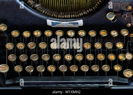 A Close-Up image of a vintage typewriter Round Keyed Keyboard.  The whole QWERT portion of the keyboard is in view as is portions of the strike bar as Stock Photo