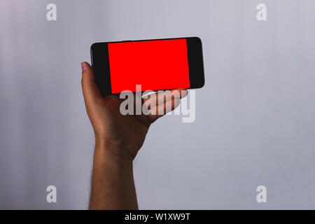 hand holding a smartphone with Empty screen with copy space for text or content Stock Photo