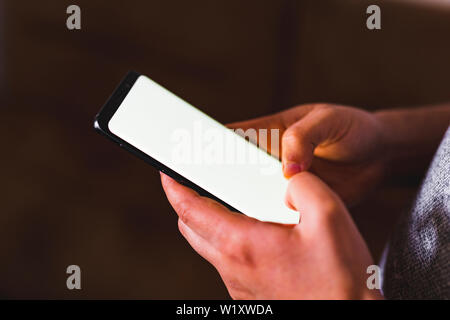 man hand holding mobile phone in coffee shop. Man using smartphone. Empty screen with copy space for text or content Stock Photo
