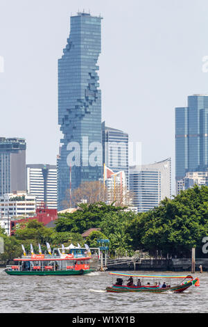 Bangkok, Thailand - April 14, 2019: Boats on the Chao Praya river with Bangkok syline in the background Stock Photo
