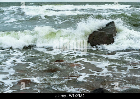 the waves beat against the rocks, the waves splash on the shore Stock Photo
