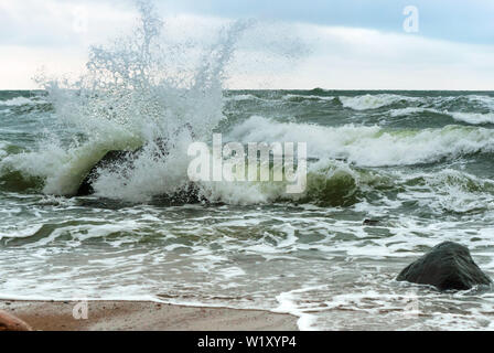 the waves beat against the rocks, the waves splash on the shore Stock Photo