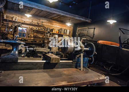 Workshop scene. Old tools hanging on wall in workshop, Tool shelf against a table and wall, vintage garage style Stock Photo
