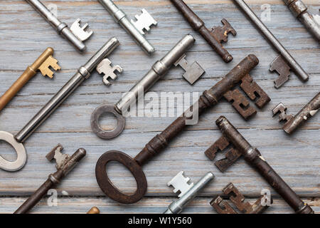 Vintage old fashioned keys on a rustic wooden background. Security concept Stock Photo