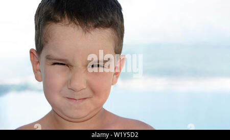 Close up portrait of young child boy making grimace emotional expressing disgust face grimacing looking at camera copy space closeup face facial expre Stock Photo