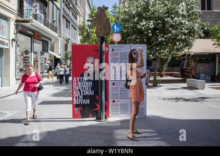 04 July 2019, Greece, Athen: A woman makes a selfie next to an advertiser with a picture of Yanis Varoufakis, former Greek finance minister and current party leader of Mera 25. On Sunday Greek voters are likely to reject extreme parties in the parliamentary elections. According to surveys, the right-wing extremist Golden Dawn party and the once strong communist party KKE do not even reach 4 percent. The right-wing populist party Anel, which sat as a small coalition partner in the government until the beginning of this year, does not even take office. Contrary to the European trend, the Greeks Stock Photo