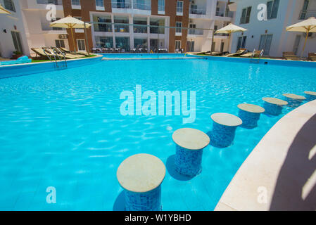 Large swimming pool with bar at a luxury tropical hotel apartment resort Stock Photo