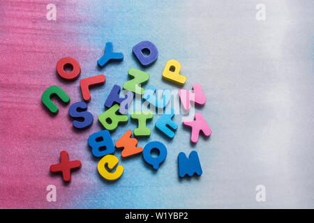 Colorful wooden letters scattered on a white background Stock Photo