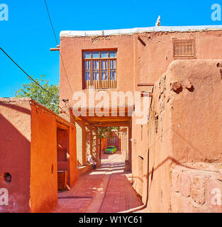 The narrow street of the oldest Iranian village, located on the slope of Karkas mount and famous for its ochre houses, Abyaneh, Iran. Stock Photo