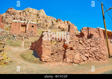 The old adobe buildings on the mountain slope and the ruins of ancient fort on the background, Abyaneh, Iran. Stock Photo
