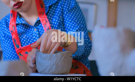 Woman making mug in pottery studio workshop Stock Photo
