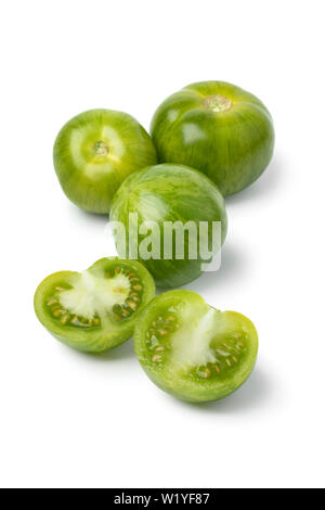 Green striped tomatoes and halved ones isolated on white background Stock Photo