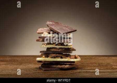 pile of mixed chocolate pieces, on wooden table Stock Photo