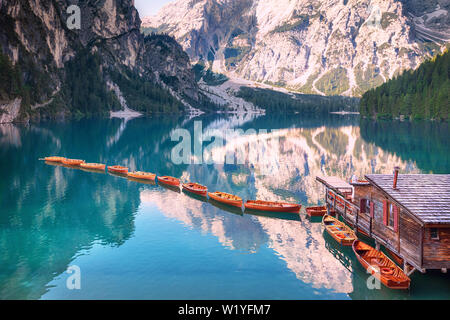 Wooden boats in a row on summer morning at Lago di Braies, Italy Stock Photo