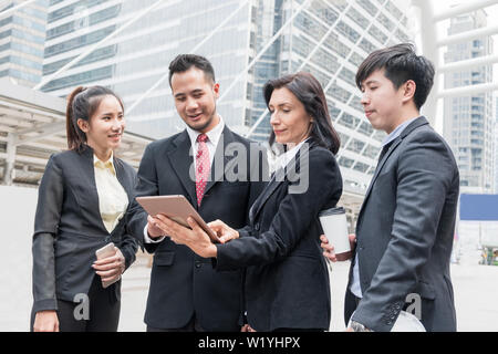 Group business person meeting with looking consult tablet for work in the city Stock Photo