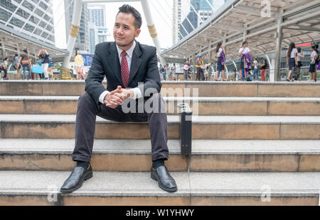 Young businessman jobless sitting on stair in the city Stock Photo