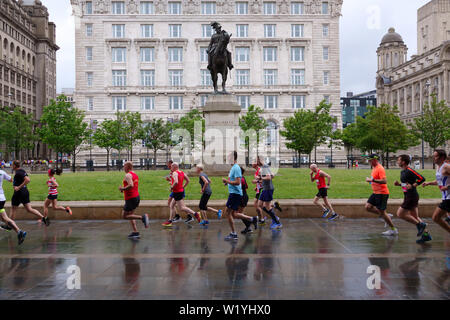 Competitors taking part in the 2019 Rock n Roll Marathon running past Liverpool's historic waterfront buildings. Stock Photo