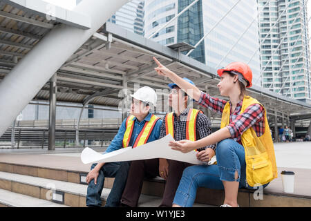 Architect engineer group meeting discussing and looking with blueprint at clity Stock Photo