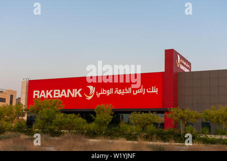 'Ras al Khaimah, RAK/ United Arab Emirates - 6/26/2019: RAK Bank red sign in evening on a main road in the northern Emirates' Stock Photo