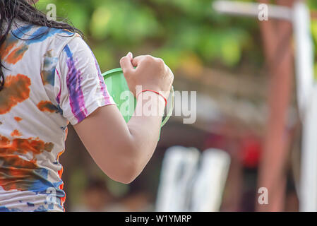 Hand holding Plastic bucket play Songkran festival or Thai new year in Thailand. Stock Photo